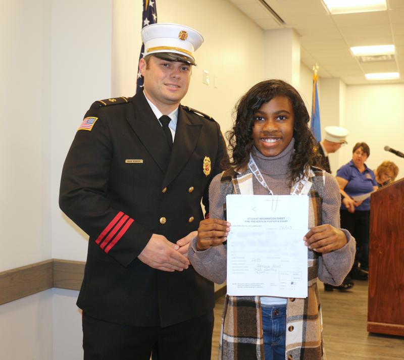 H.O. Brittingham Elementary fifth-grader Amani Johnson, with MFD President Brian Reynolds Jr., received third place.